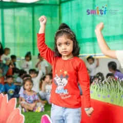 A young performer stands confidently on stage, her arm raised in a powerful pose. Our events give every child a chance to shine.