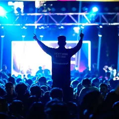 Capturing the peak energy of a college DJ night. This silhouette shot against the bright stage lights shows how I play with light and shadow to convey the electric atmosphere and collective excitement of the crowd.