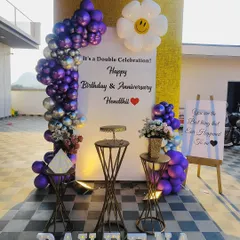 This setup was for a special double celebration of a birthday and anniversary. I used a purple and silver balloon arch and a personalized sign to honor both occasions, complete with marquee letters for the name.