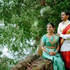Another angle of the couple enjoying a quiet moment by the lake. The lush green surroundings provide a perfect, tranquil backdrop for their portrait.