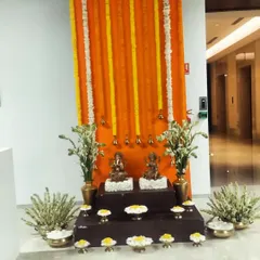 Another traditional setup for an office Diwali party. We created a backdrop of orange marigold garlands and placed idols on a tiered platform, surrounded by brass pots and fresh flowers.