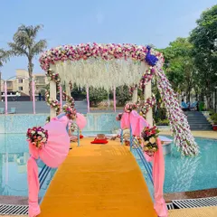 For a poolside wedding, I designed this unique mandap featuring a floral peacock. The structure is adorned with pink and white flowers, creating a stunning visual that appears to float over the water.