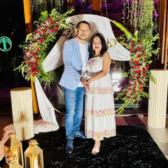 A happy client at a small send-off party we decorated. We created a lovely floral arch with red roses and white drapes for their photos.