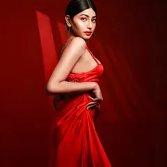 The power of red. In this shot, we used a vibrant red backdrop and focused lighting to create a dramatic silhouette, emphasizing the model's form and confidence.