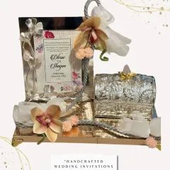 A handcrafted wedding invitation that reflects your story. This set includes a silver-coated photo frame with the invitation details, paired with a small, ornate silver box, all presented on a decorated tray.