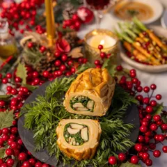 A cross-section of the perfectly cooked Chicken Wellington, revealing the savory mushroom and spinach filling. A true culinary delight for your Christmas table.