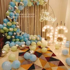 Celebrating a 36th birthday in style with this balloon and light setup. A half-arch of blue, yellow, and silver balloons is paired with large marquee numbers, all set against a curtain of twinkling fairy lights.