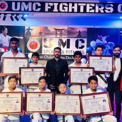 The full team of new black belts with their coaches, holding their official certifications.