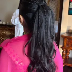 A fun and youthful ponytail with multiple thin braids scattered throughout. This adds texture and interest to a simple high ponytail and is perfect for a Mehendi or a young bridesmaid.