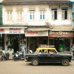 A Kaali-Peeli taxi parked on a cobblestone street in an old neighborhood. This shot is rich with nostalgic charm, capturing the timeless character of both the vehicle and the city's architecture.