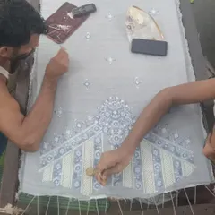 Here, my master craftsmen are at work, meticulously hand-embroidering a piece inspired by Pietra Dura art. Every stitch is a testament to the tradition and skill that defines my work.