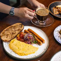 Here is my classic breakfast platter, complete with a fluffy omelette, sausages, and toast, enjoyed with a freshly brewed Americano. It’s the perfect combination to ease into your morning.