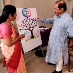 Family members joining in on the fun, casting their vote for 'Boy or Girl' on the thumbprint tree. It's a great way to get everyone involved in the excitement.