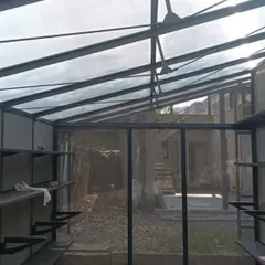 A work-in-progress shot of a lightweight metal structure. The roofing combines fabric and translucent panels, designed to fill the interior with a soft, diffused natural light, much like a greenhouse.