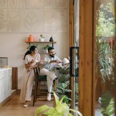 A quiet moment over coffee inside a beautifully designed cafe. The warm interior and natural light from the window create a cozy and intimate atmosphere for a couple's shoot.