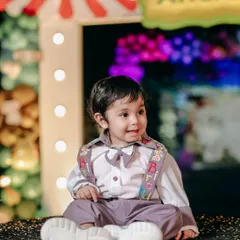 A big, happy smile from the birthday boy at his carnival party. The colorful background and his joyful expression perfectly capture the spirit of the day.