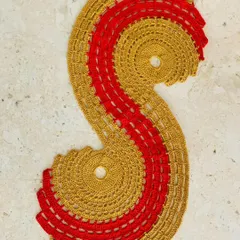 My spiral table runner in a festive gold and red combination. This unique S-shaped design is perfect for adding a dramatic and celebratory touch to your decor.
