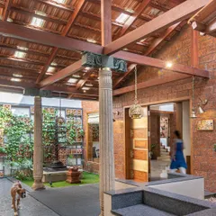 I love creating modern interpretations of the traditional Indian courtyard. Here, reclaimed wooden pillars and a terracotta tile roof frame a central green space, making for a grand yet welcoming entrance that feels rooted in heritage.