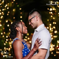 A quiet moment together amidst the celebration. The couple shares a smile against a backdrop of firefly lights, a simple yet magical setting that highlights their love.