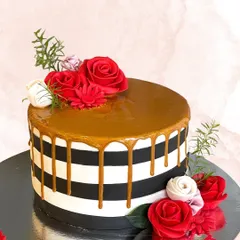 A bold and stylish cake with black and white stripes, a rich caramel drip, and vibrant red roses. This design is perfect for someone with a classic yet modern fashion sense.