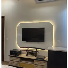 A unique bedroom TV unit with a custom backlit panel that creates a soft glow. The samurai sword display adds a personal and striking touch to the space.
