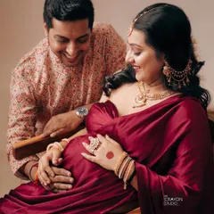 The shared joy between partners is a beautiful part of the maternity story. Here, his happy gaze meets hers as they both gently hold the baby bump, a moment of shared anticipation.