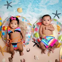 A day at the beach for these adorable twins. This summer-themed shoot features surfboards, seashells, and tiny swimwear for a fun and unique twin portrait.