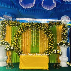 This outdoor Haldi setup under a pandal shows how we can transform any space. The bright blue, yellow, and green colors are perfect for a daytime celebration.