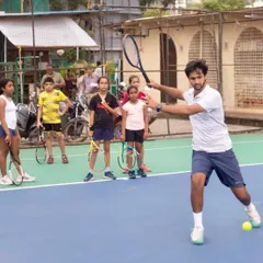 I believe in leading by example. Here, I demonstrate the correct forehand technique to a group of young players, showing them the body mechanics required to hit a clean, powerful shot.