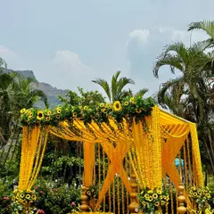 For this outdoor Haldi ceremony, we built a stunning mandap drenched in vibrant yellow. The structure is heavily decorated with marigold garlands and fresh sunflowers, creating a traditional and cheerful atmosphere against a beautiful natural backdrop.