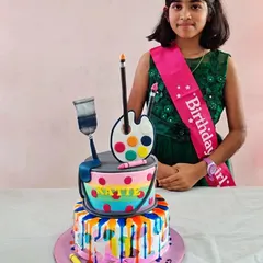 Another photo of the birthday girl and her colourful, art-inspired cake.