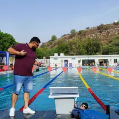 Chasing excellence, one-hundredth of a second at a time. Here I am timing a swimmer during a practice set, providing immediate feedback to ensure they are hitting their target pace and maintaining perfect form.