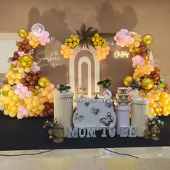 A modern take on a baby shower with a "Little Sunshine" theme. The earthy tones of the balloon decor, combined with pampas grass and a neon "Oh Baby" sign, create a chic and warm welcome.