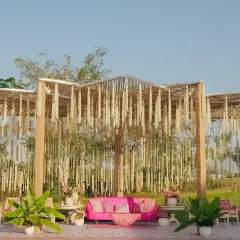 A wide shot of the serene bamboo pergola, draped in vibrant blooms. This setup was designed to be the perfect blend of nature and elegance for an outdoor Mehendi celebration.