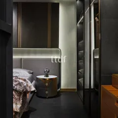 This bedroom is artfully designed to evoke opulence with premium furniture. The space features a circular bedside console and elegant back-painted wardrobe shutters, reflecting a lifestyle of luxury while meeting the demands of modern living.