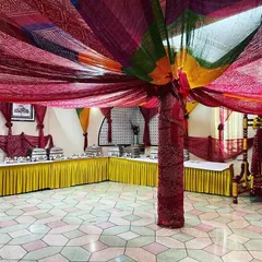 A vibrant, Rajasthani-themed buffet setup for a sangeet ceremony. The colourful bandhani drapes and traditional decor create a festive atmosphere for guests.