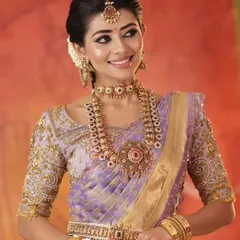 A stunning look featuring a lavender Kanjeevaram silk saree paired with a heavily embroidered custom blouse. This combination is timeless, elegant, and perfect for a wedding muhurtham or reception.