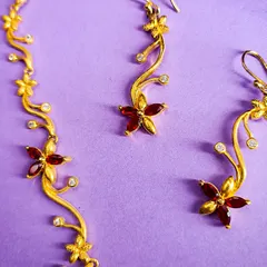 A close-up of the matching earrings for the gold-plated floral necklace set. The design mirrors the necklace's delicate vine motif.