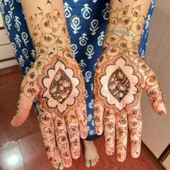 Full bridal henna with a unique design featuring a central leaf shaped motif filled with intricate floral work. The surrounding area is covered in a delicate net of vines and flowers.
