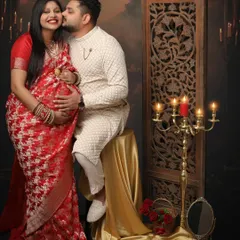 A moment of pure joy and affection. This couple celebrates their journey in traditional attire, with the dad-to-be placing a sweet kiss on his partner's cheek.