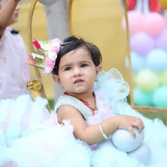 This photo shows the birthday girl in her element, sitting in a decorative wicker chair surrounded by pastel balloons. It’s a great way to capture the theme and atmosphere of the party.