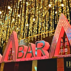 A bold and modern bar sign, lit in red, making it a clear and stylish focal point for the beverage station at a sangeet or cocktail event.