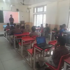 An instructor leads a classroom session at DAV Sundar Nagar. Students are equipped with laptops, ready to follow along with the practical coding exercises.