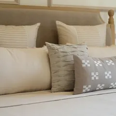 The soul of our work lies in the details. This close-up reveals the subtle textures, from delicate pintucks to geometric block prints, that define our neutral cushion collection, designed for an Alibaug villa.