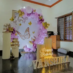 An intimate butterfly-themed setup for a home party. I used a circular backdrop, a neon sign, and marquee letters spelling out the name.