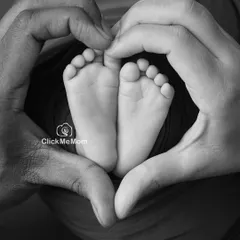 Sometimes the most powerful stories are told without color. This black and white portrait captures the love that surrounds your new baby, with parents' hands forming a heart around those perfect little feet.