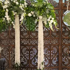 A close-up of the floral arrangement on the wooden screen. I used a mix of fresh white flowers and green leaves to create a look that is both classic and refreshing.