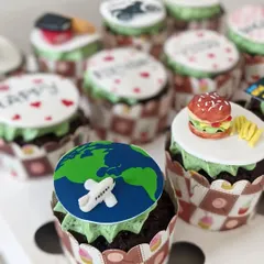 A close-up of my customized cupcakes. This set includes toppers for a world traveler and a foodie, with a mini fondant burger and fries.