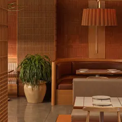 A detail shot at Biergarten showing the interplay of textures. The terracotta wall, wooden screen, and pleated fabric lampshade come together to create a layered and tactile interior design experience.