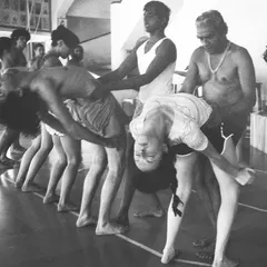 Guruji B.K.S. Iyengar adjusting students. His teaching clarifies that yoga is not a religion but a practice that makes a human being a better human being, uniting the body with the mind and drawing aside the veils of illusion.